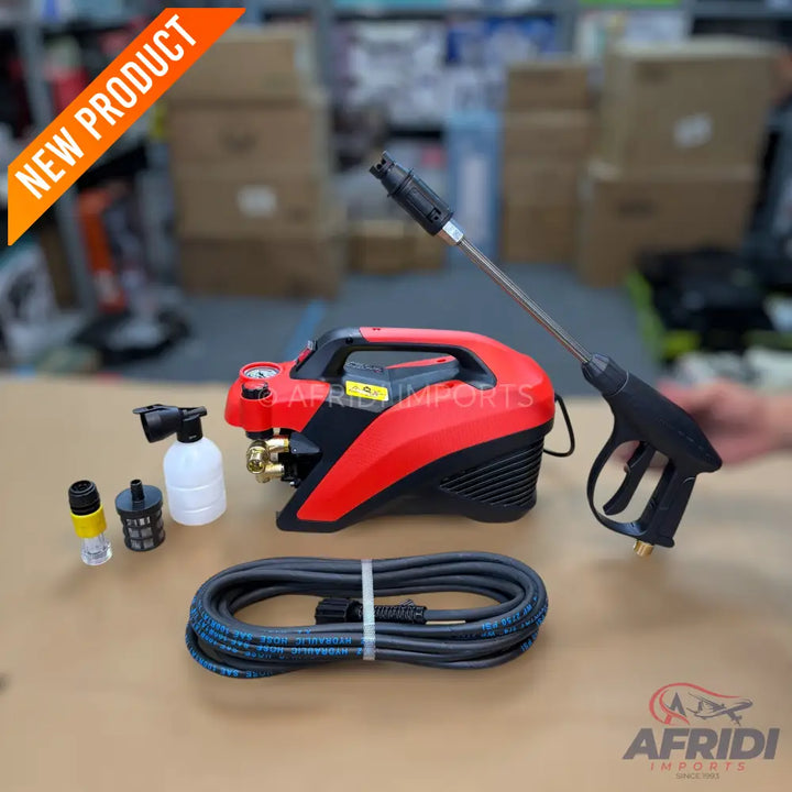 A compact red and black pressure washer with its spray gun, hose, and attachments.
