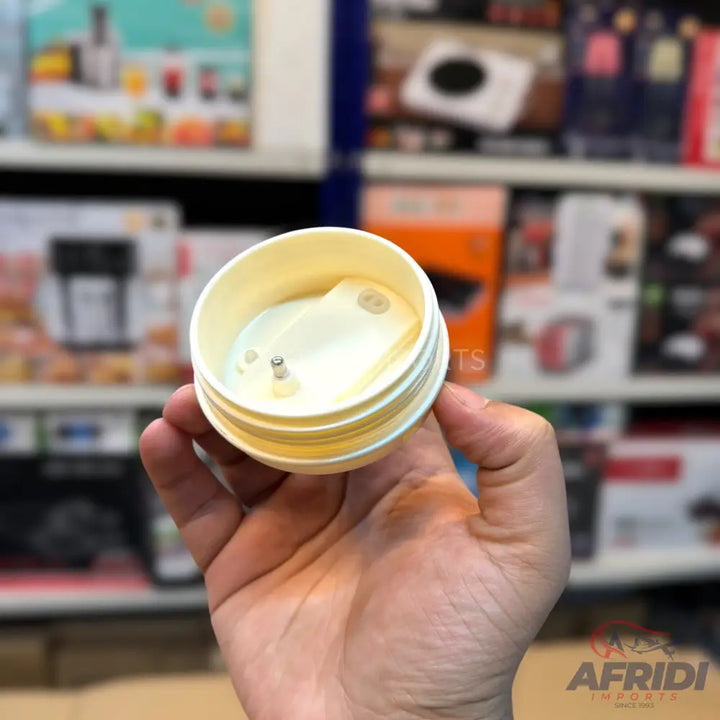 An open, empty, light-yellow plastic container with screw threads.