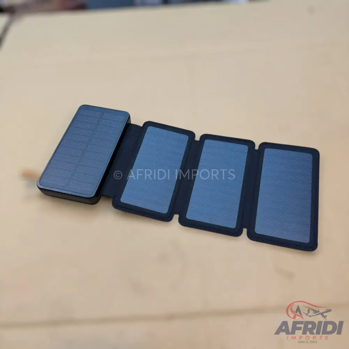 A black, foldable, multi-panel solar charger.