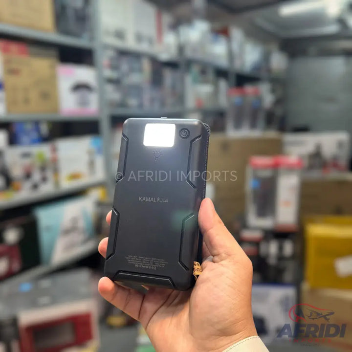 Black, rugged power bank with an illuminated flashlight and a gold-colored attachment.