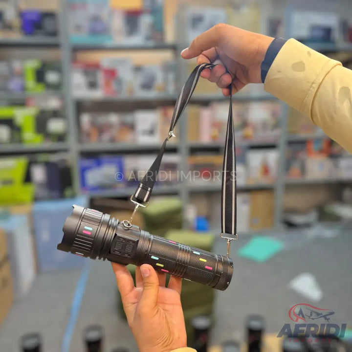 Black flashlight with colorful indicator lights and a shoulder strap.