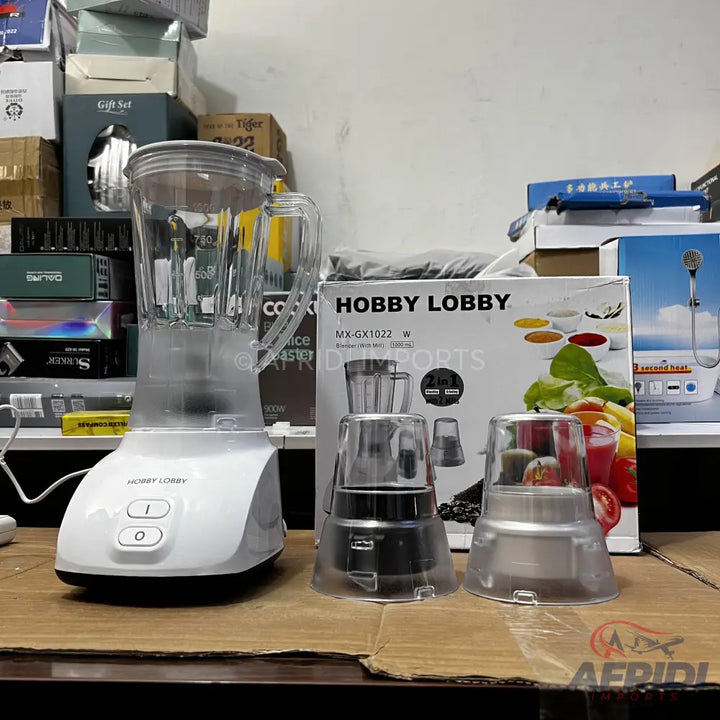 A white blender with two additional grinding attachments.