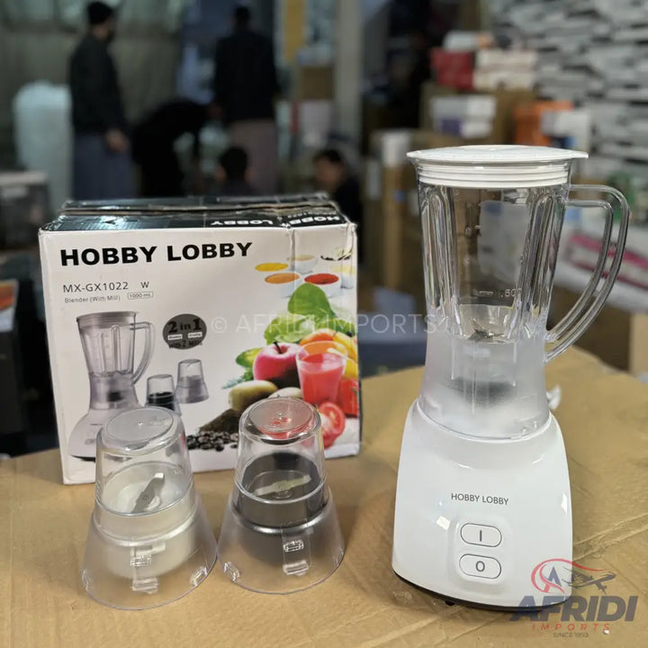 A white blender with two additional grinding attachments.