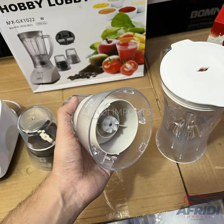 A white and clear plastic blender with two interchangeable attachments.