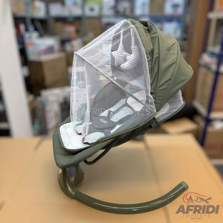 An olive green baby bouncer with a mesh cover and hanging star toys.