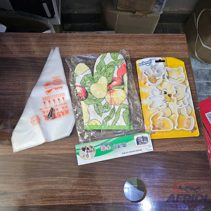 Baking accessory kit with an oven mitt, cookie cutters, and piping bag.