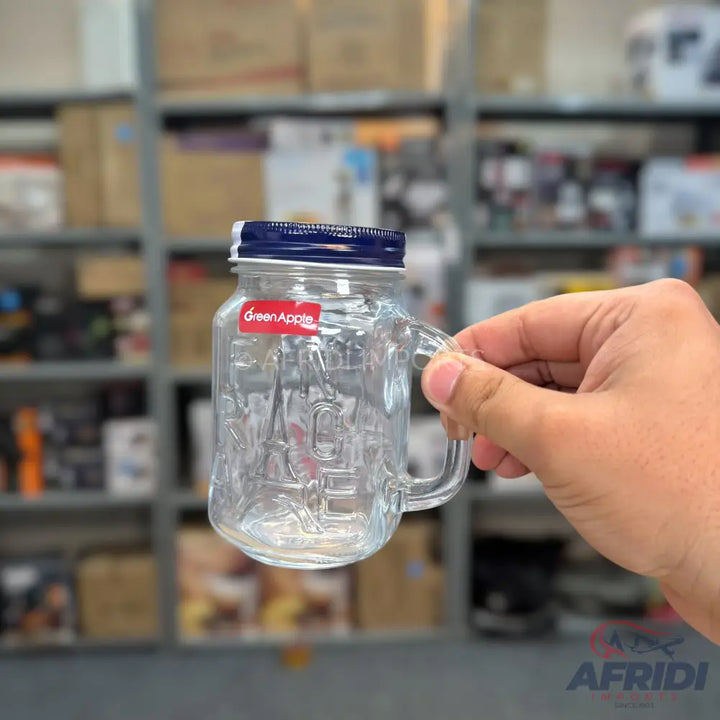 Clear glass mason jar mug with a blue lid and handle.