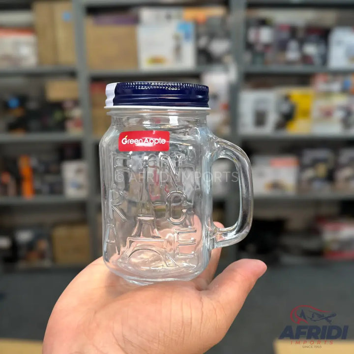 Clear glass mason jar mug with a handle and a dark blue and white screw-on lid.