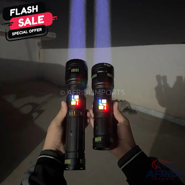 Two hands holding black tactical flashlights with illuminated multi-colored side panels and bright, focused beams.