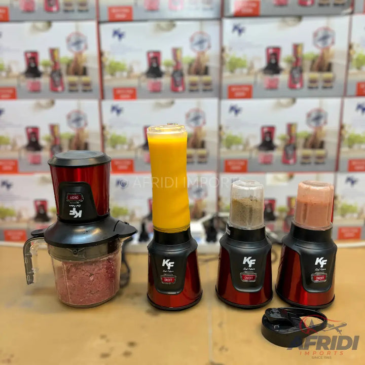 A set of red and black kitchen blenders and choppers with various attachments, including one with a tall cup containing orange juice, one with a smaller cup containing a light brown mixture, one with a small cup containing a pink mixture, and a food chopper with a clear bowl containing ground meat.