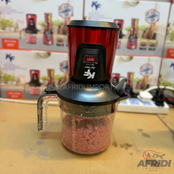 Red and black electric meat grinder with a clear container of ground meat.
