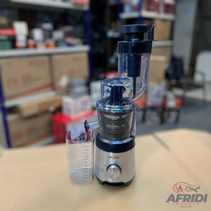 A silver and black electric juicer with a clear pulp container and a measuring cup.
