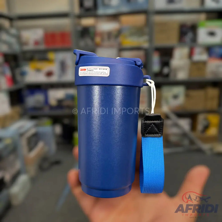 Blue insulated tumbler with a flip-top lid and a blue carrying strap.