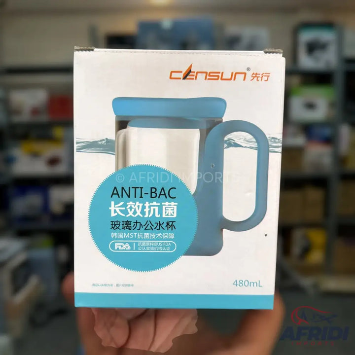 A boxed anti-bacterial glass mug with a blue silicone sleeve and handle.