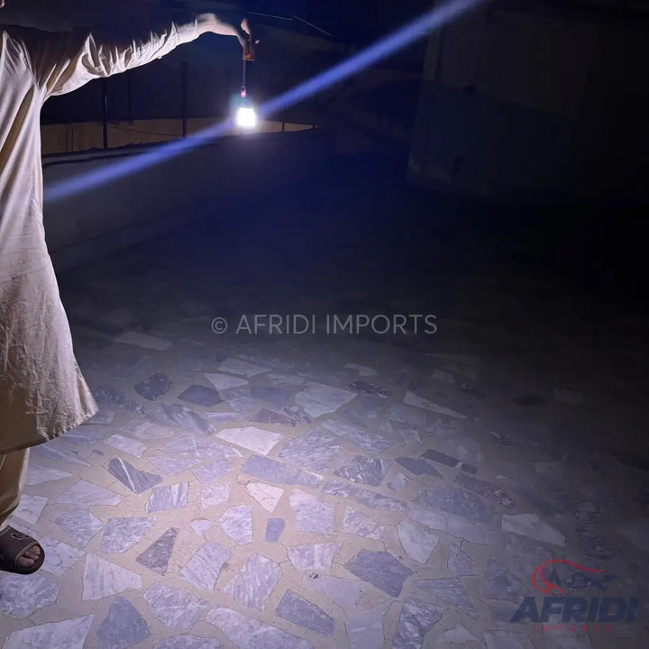 Person holding a bright, portable lantern.