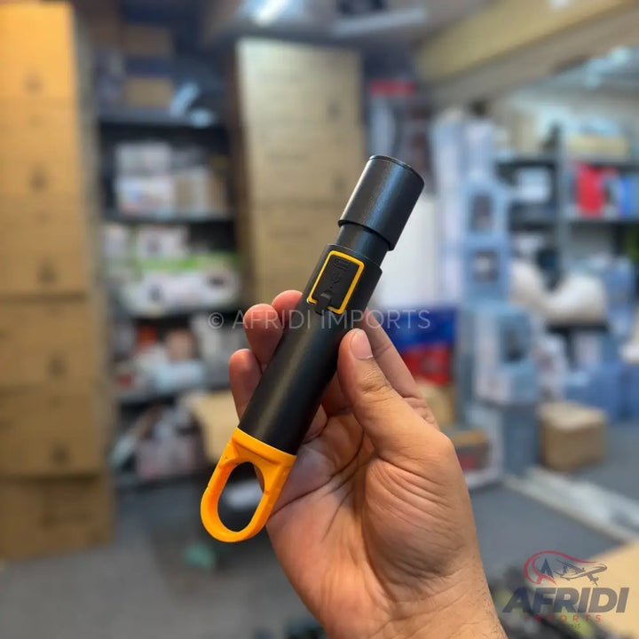 Black handheld microphone with a yellow power button and a yellow loop at the base.