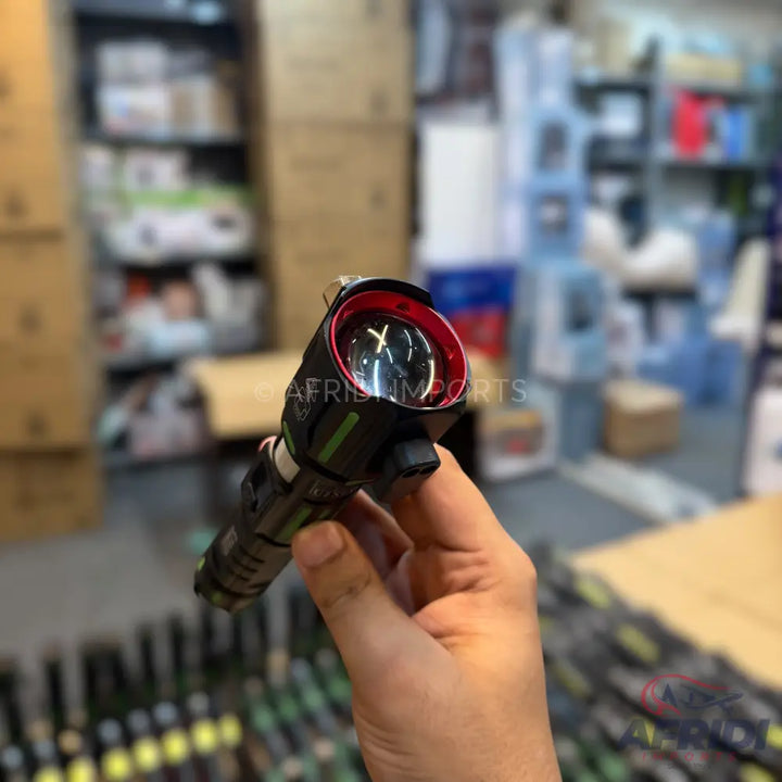 A black tactical flashlight with a red bezel and a clear lens.