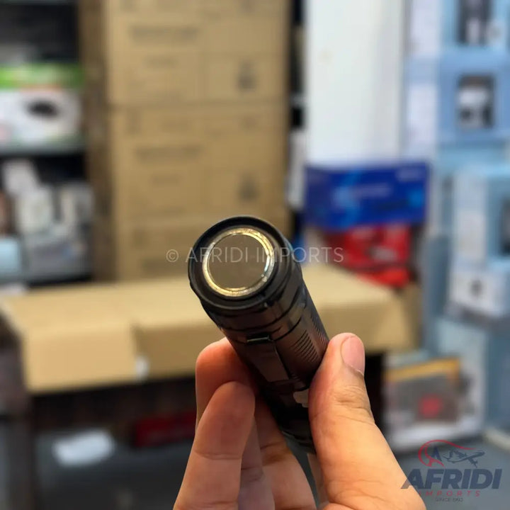 A black, handheld flashlight with a metallic reflector.