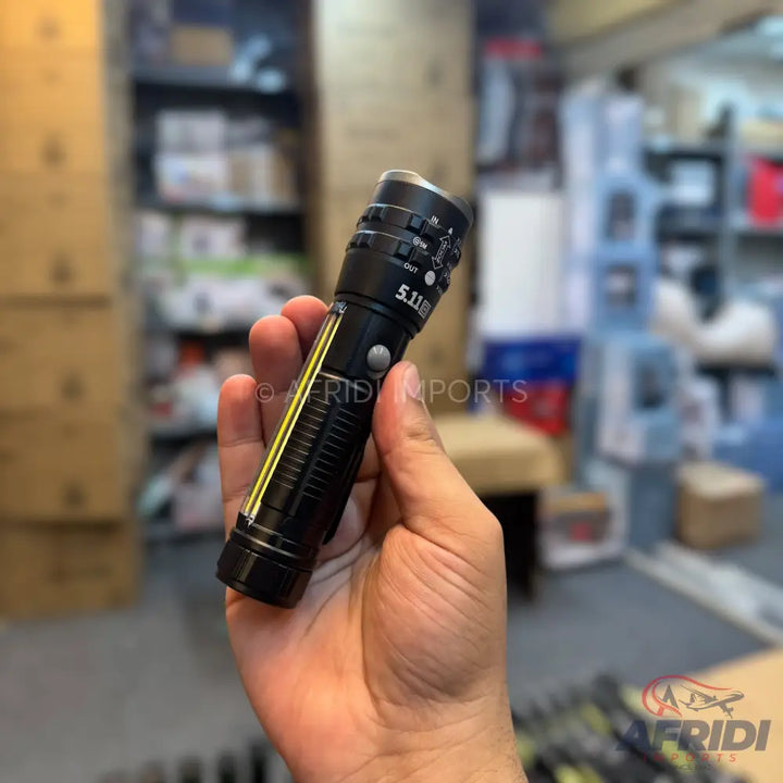 A black tactical flashlight with a reflective yellow stripe, featuring multiple function buttons and a silver-colored head.