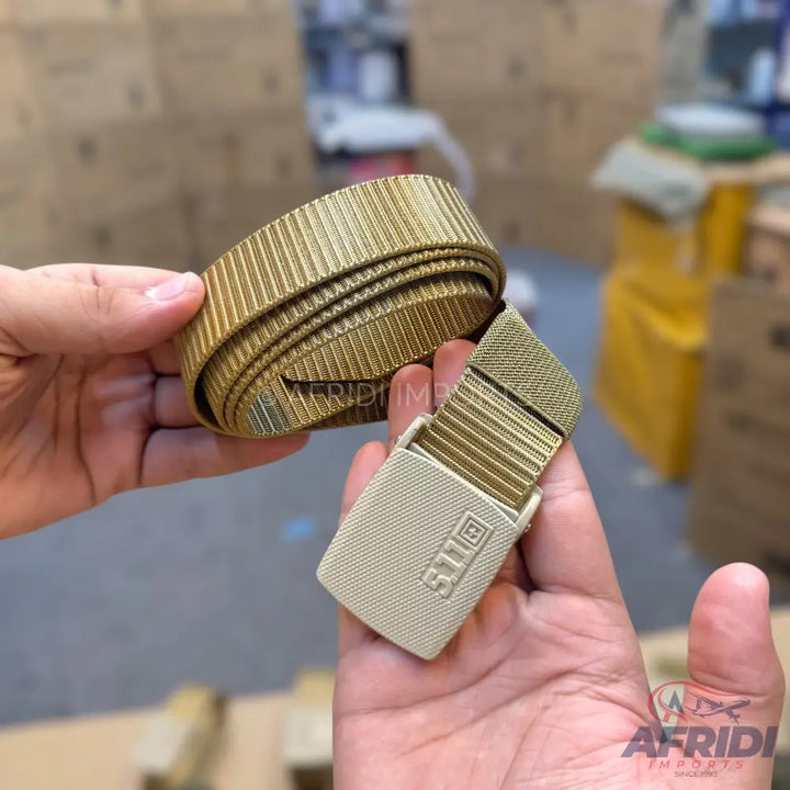 A tan web belt with a matching adjustable buckle.