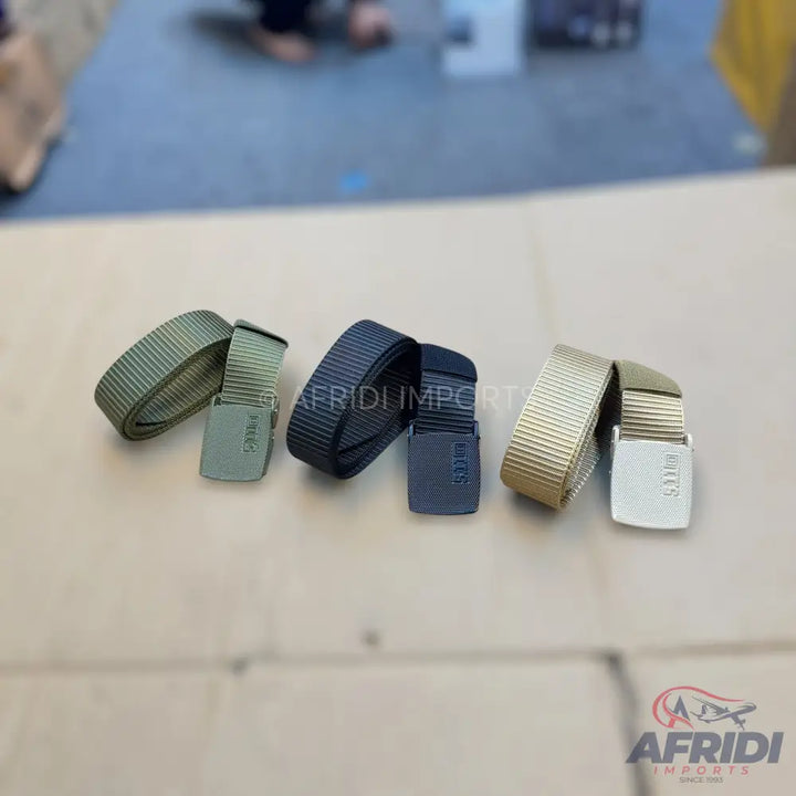 Three rolled tactical belts in olive green, black, and tan.