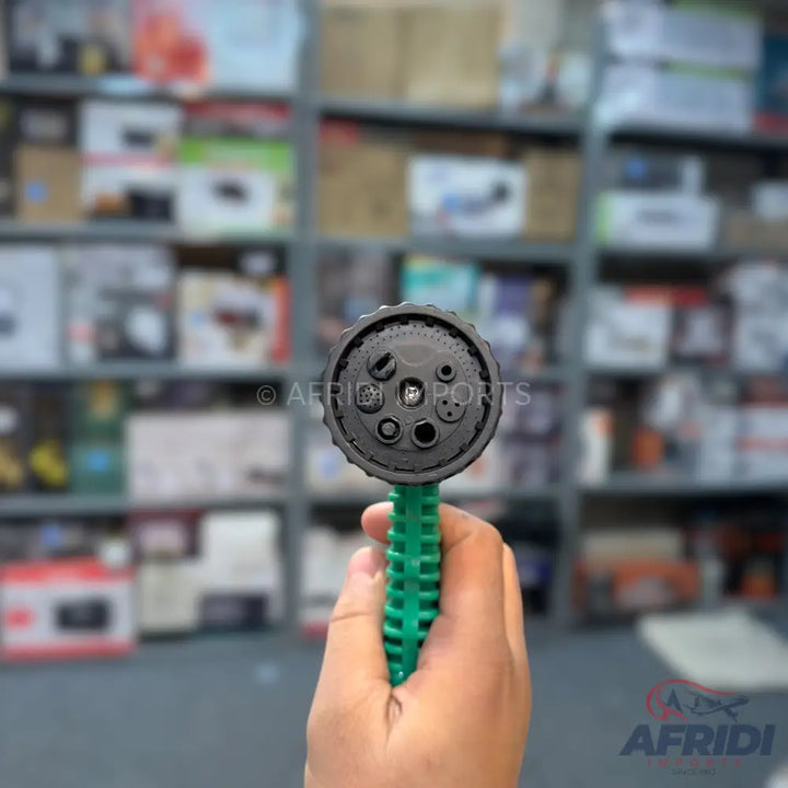 A handheld green and black multi-pattern spray nozzle.