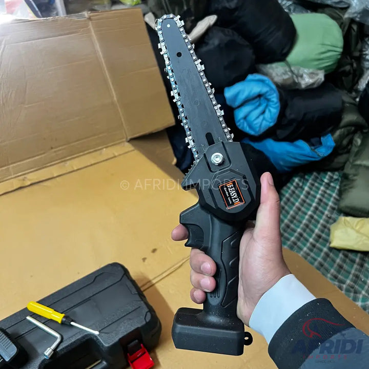 A handheld, battery-powered mini chainsaw with a black casing and a silver chain.