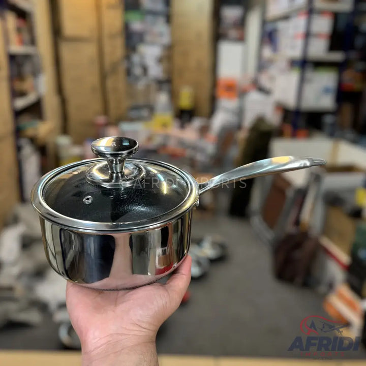 Shiny stainless steel saucepan with a clear glass lid and metal handle.