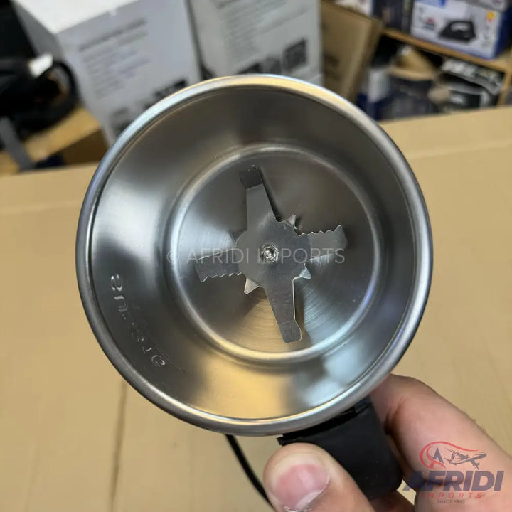 A stainless steel grinder cup with a four-pronged blade.