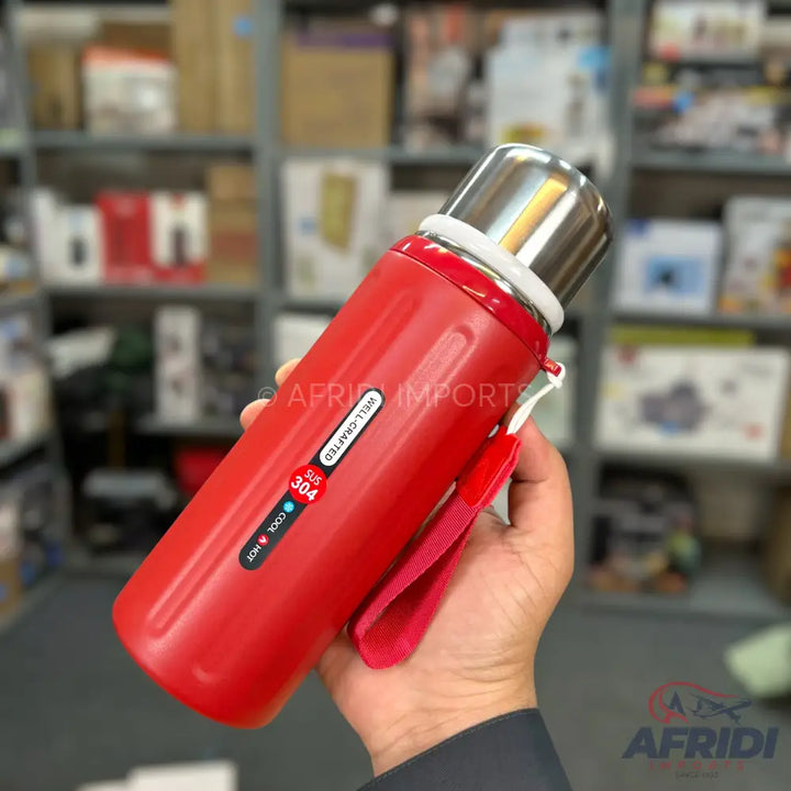 Red insulated water bottle with a stainless steel cap and a carrying strap.