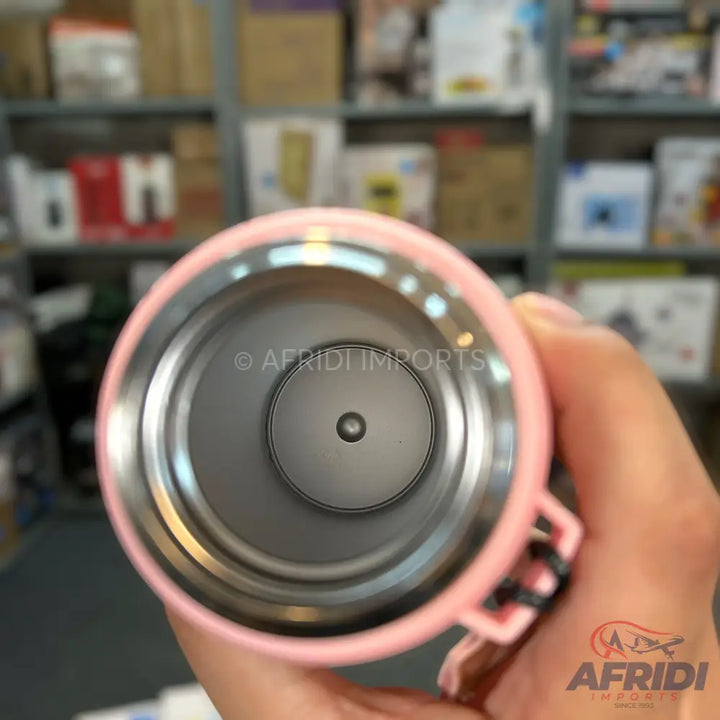 Pink insulated travel mug with a stainless steel interior and a small circular opening at the bottom.