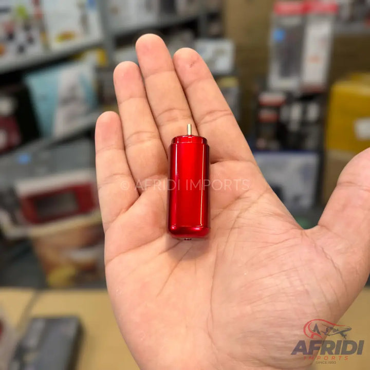Red metallic cylindrical motor with an exposed gold-colored shaft.