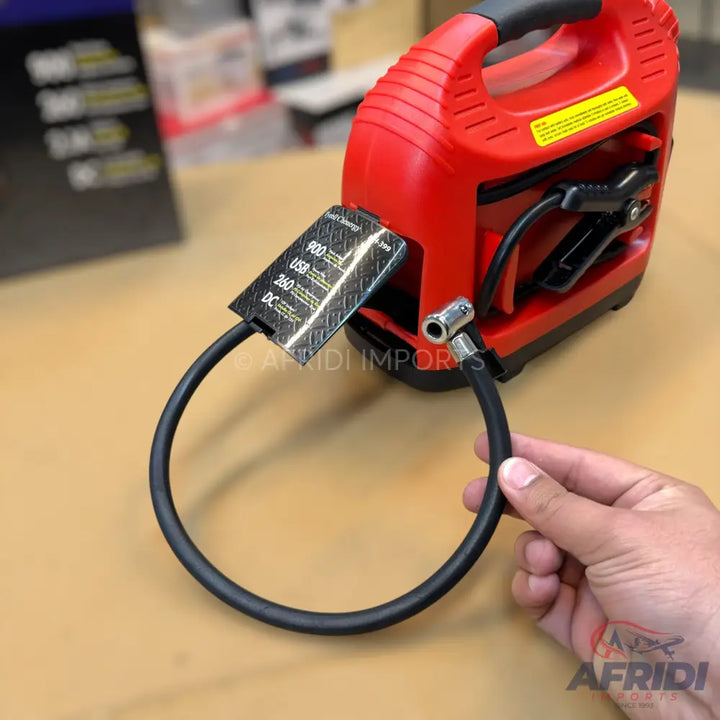 Red portable jump starter with an air compressor.