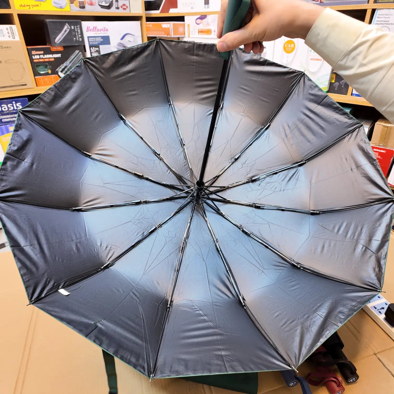 Open dark-colored lot imported folding BMW automatic umbrella with reflective interior panels