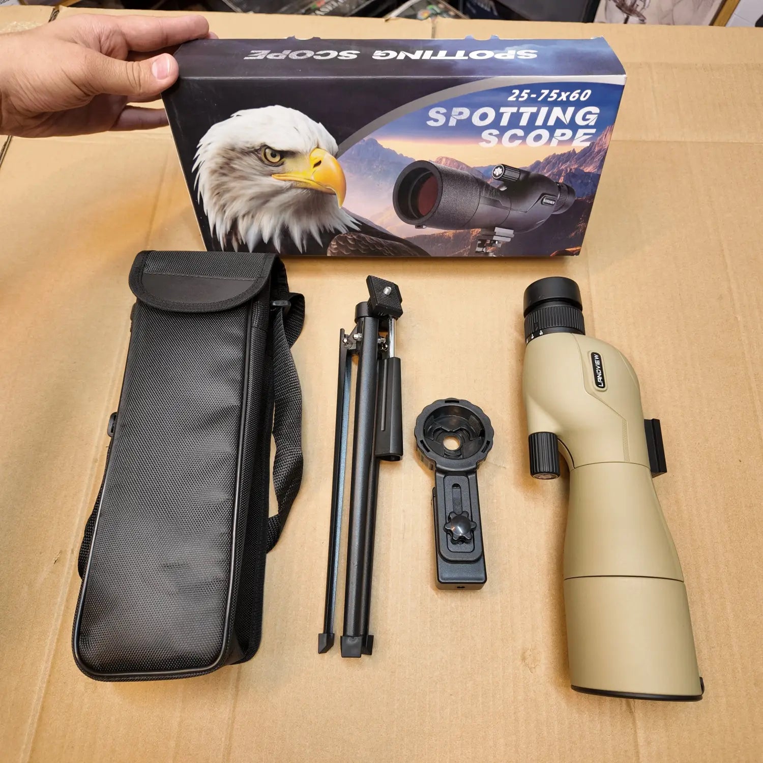 Tan spotting scope with black carrying case tripod and mobile clip for enhanced viewing