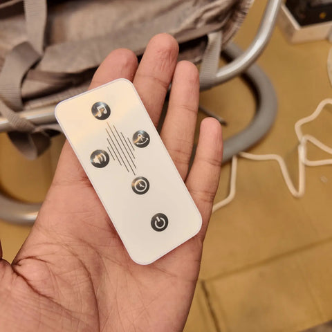 White remote control with five function buttons for the imported Mastela Electric Baby Swing