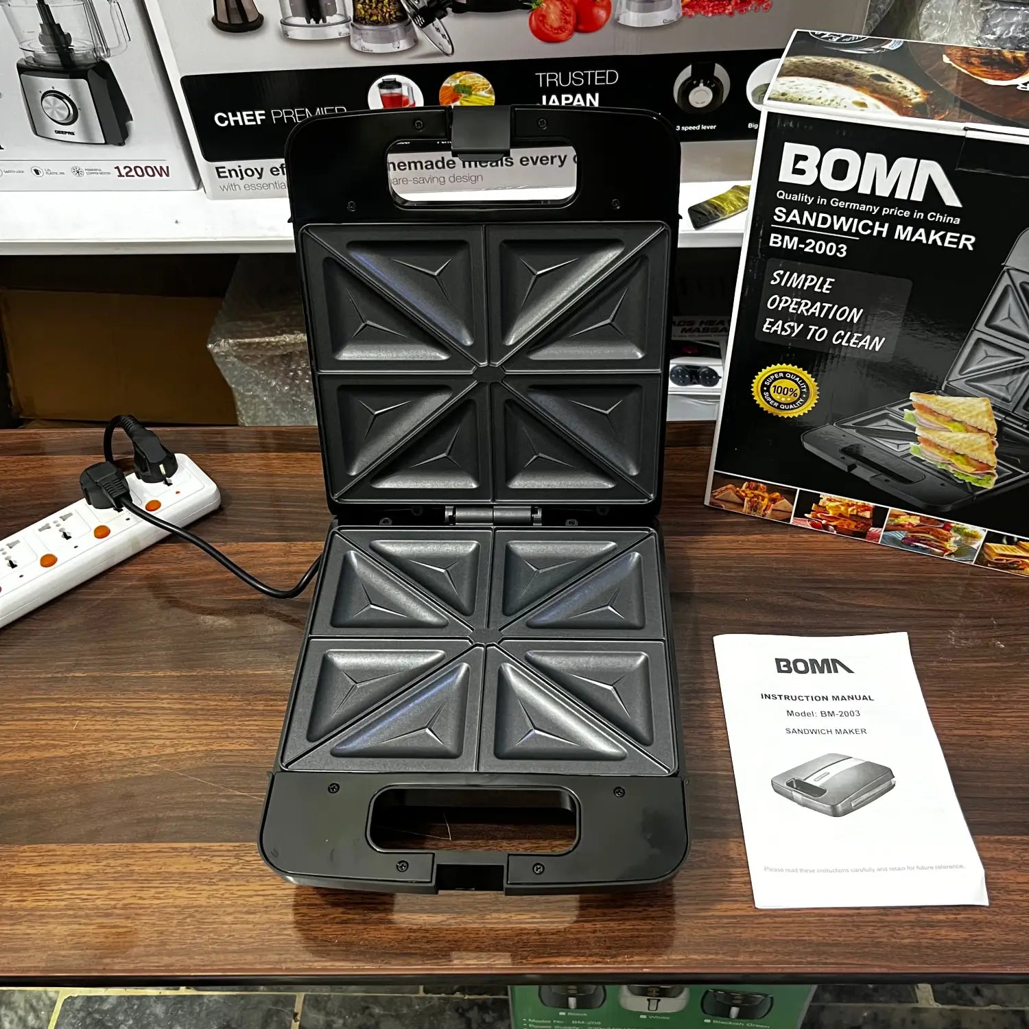 Open black electric sandwich maker with four triangular compartments, German Lot imported Boma