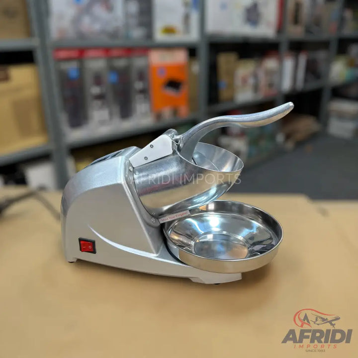 Silver electric ice shaver with a stainless steel bowl and a red power switch.