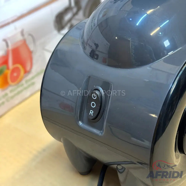 Dark grey electric citrus juicer with a three-position rocker switch.