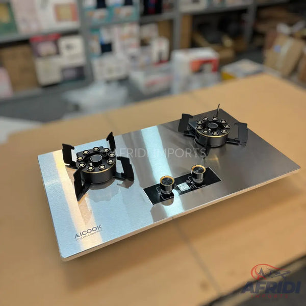 Two-burner stainless steel gas cooktop with black and gold control knobs.
