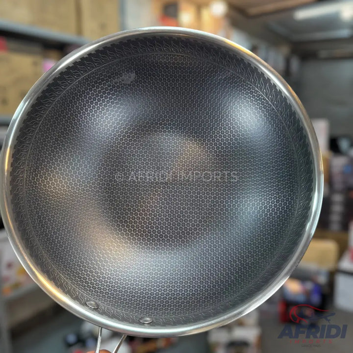 A stainless steel wok with a honeycomb-patterned non-stick interior.