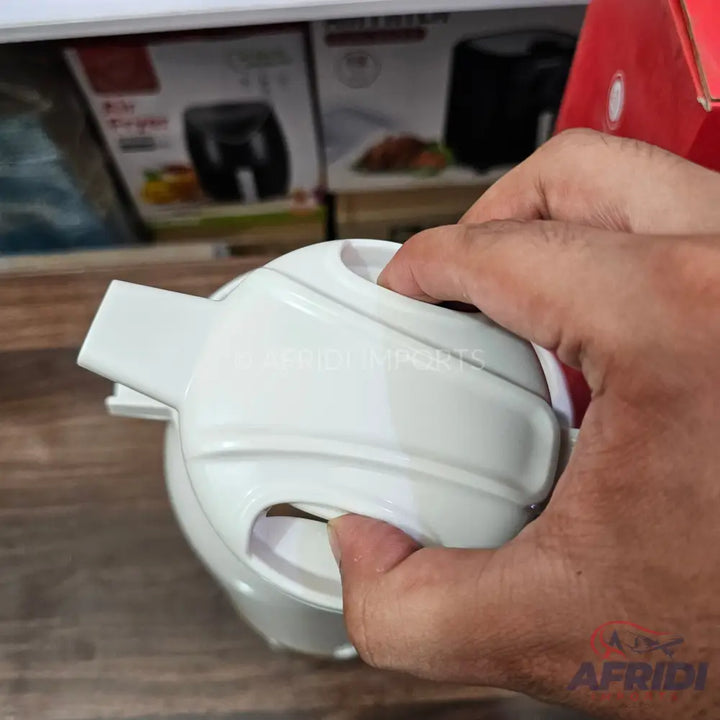 A white, handheld kitchen chopper with a pull-cord mechanism.