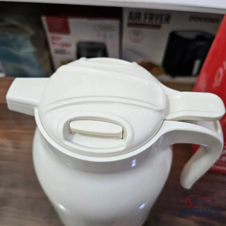 White insulated beverage carafe with a handle and push-button lid.