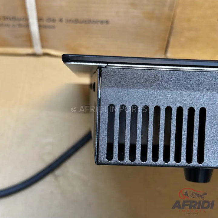 A black induction cooktop or hot plate with a metal vented side.