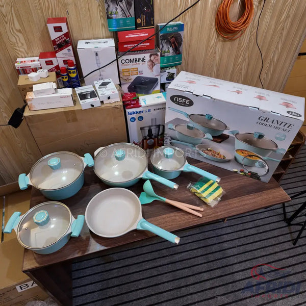 A set of light blue and white granite cookware including pots, pans, and utensils.