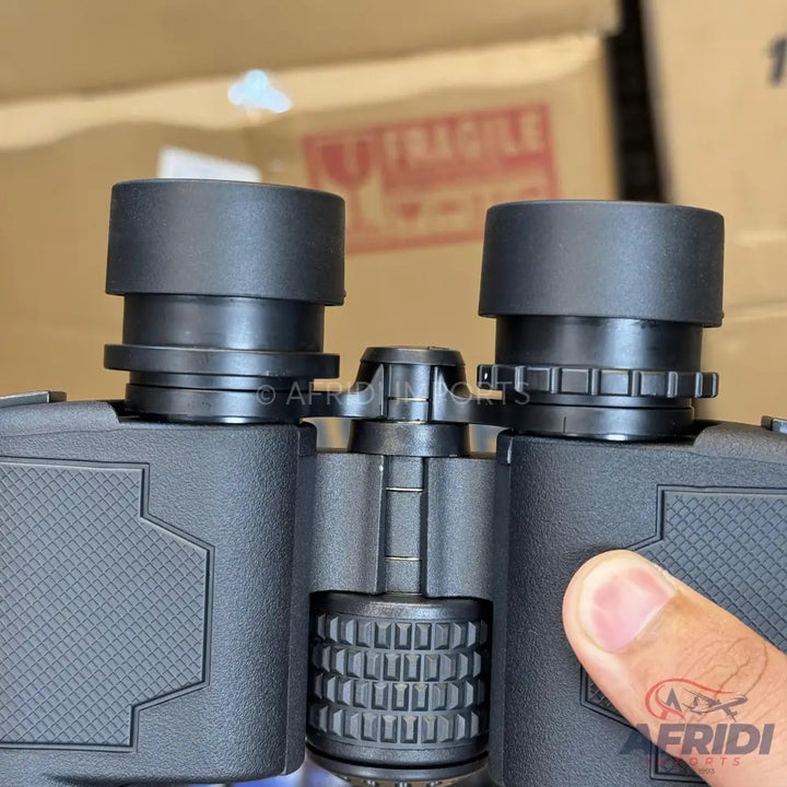 A pair of black binoculars with adjustable eyepieces and a textured grip.