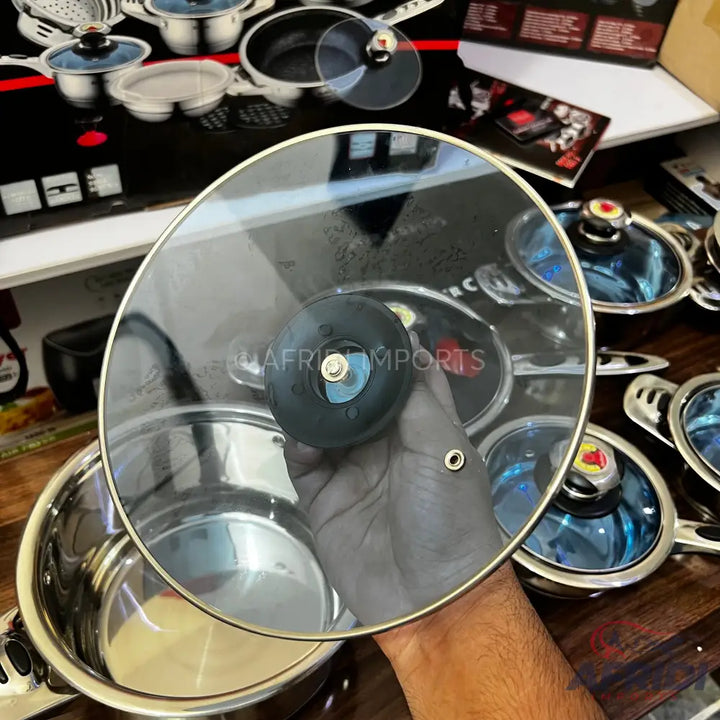 A stainless steel cooking pot with a glass lid.