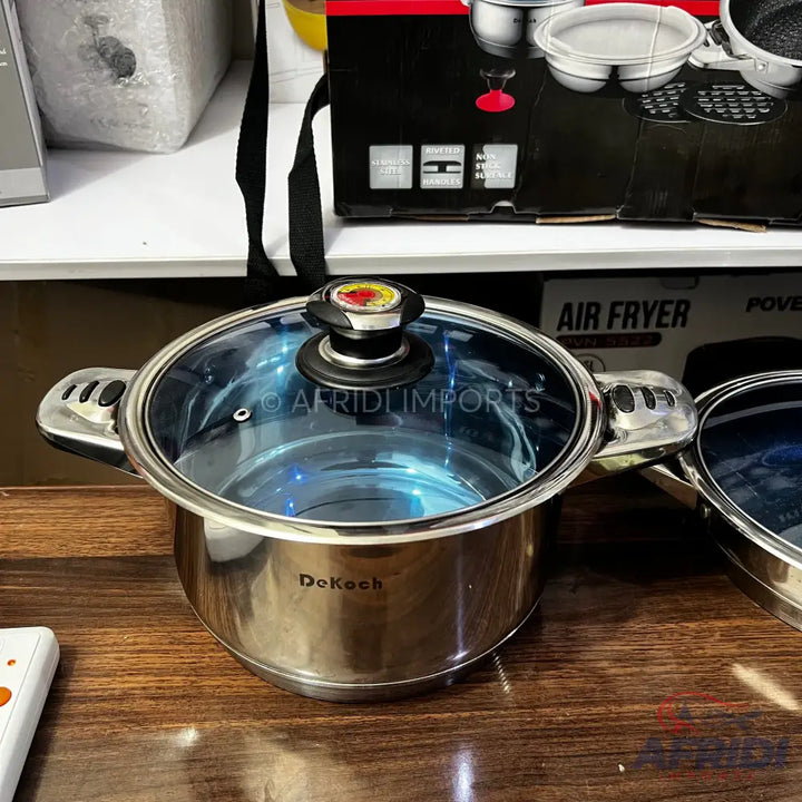 Stainless steel cooking pot with a glass lid and ergonomic handles.