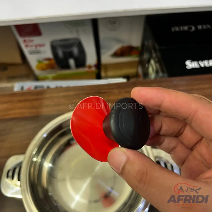 A lid handle with a red base and a black knob.