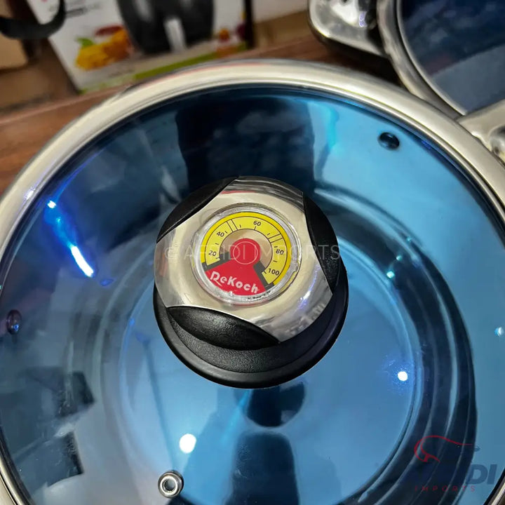 Stainless steel cooking pot with a blue-tinted glass lid and an integrated thermometer knob.
